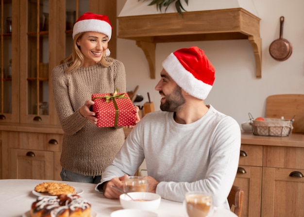 Couple wearing christmas hats indoors