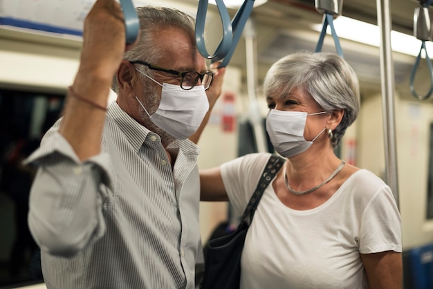 ニューノーマルで電車の中でマスクを着用しているカップル