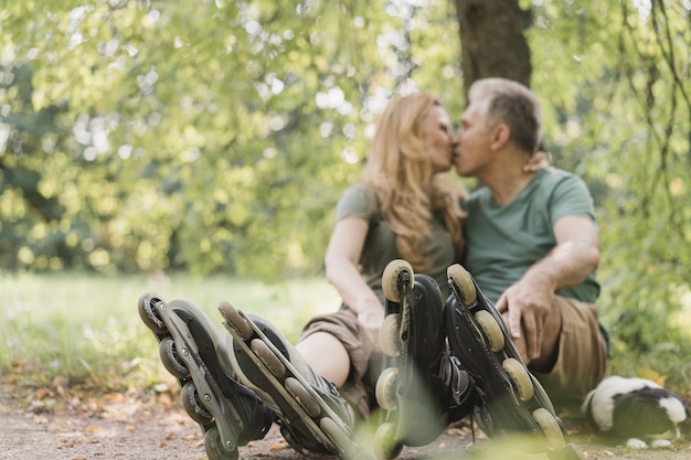 Free photo couple wearing roller skates being in the park