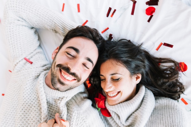 Free photo couple on white sheet with confetti