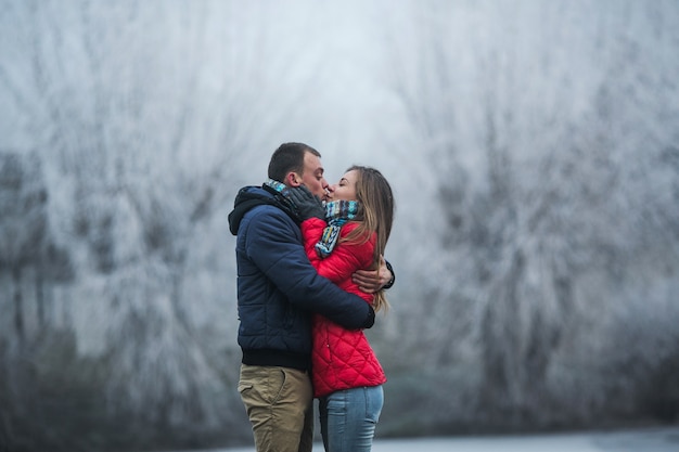 Couple in winter forest near lake