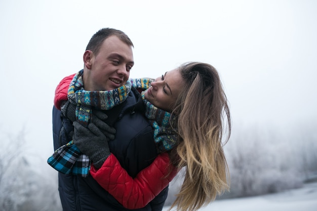 Couple in winter forest near lake