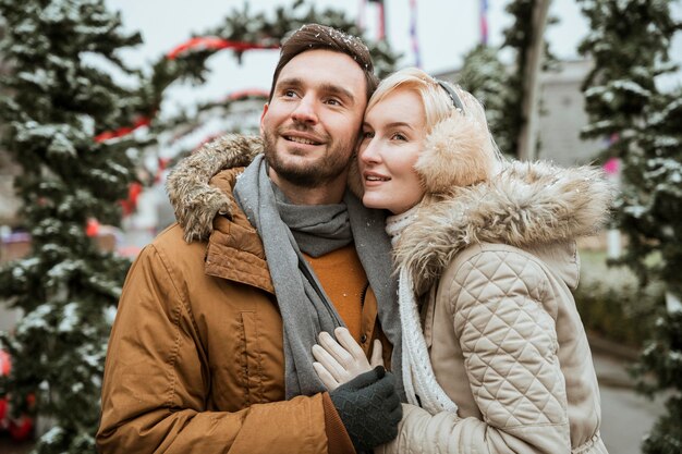 Couple in winter hugging and looking away