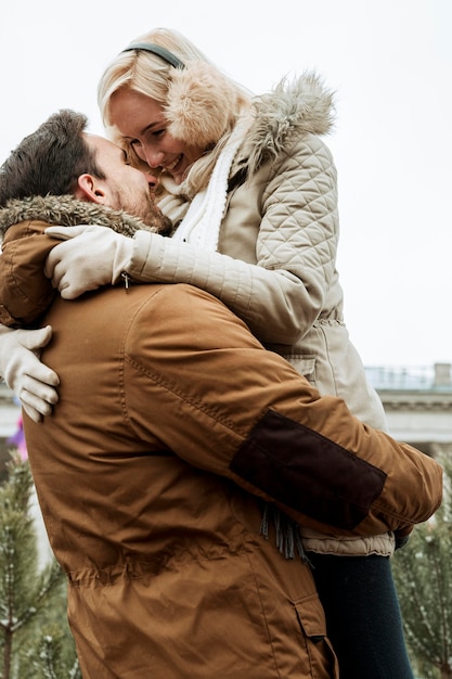 Free photo couple in winter hugging low view