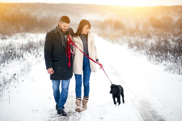 Couple in winter in the street with dog