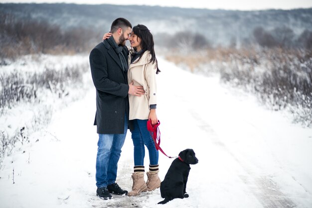 Couple in winter in the street with dog