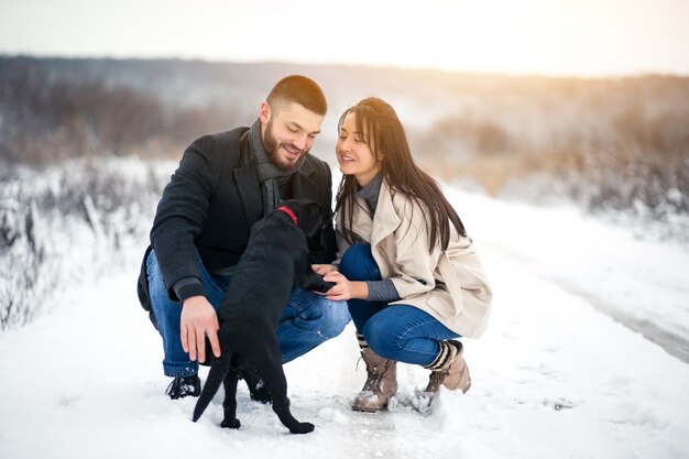 Couple in winter in the street with dog