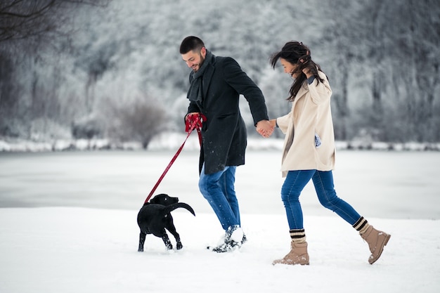 Couple in winter in the street with dog