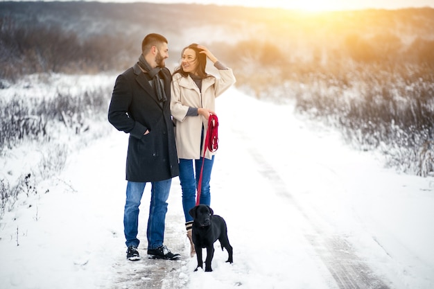 Couple in winter in the street with dog