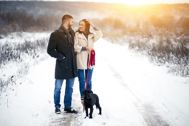 Couple in winter in the street with dog