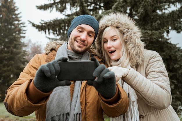 Couple in winter taking a selfie front view