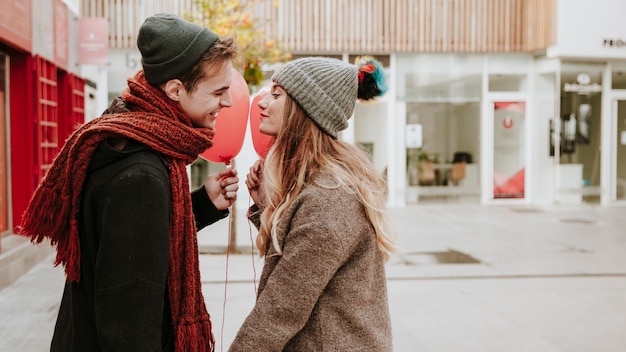 Free photo couple with balloons kissing