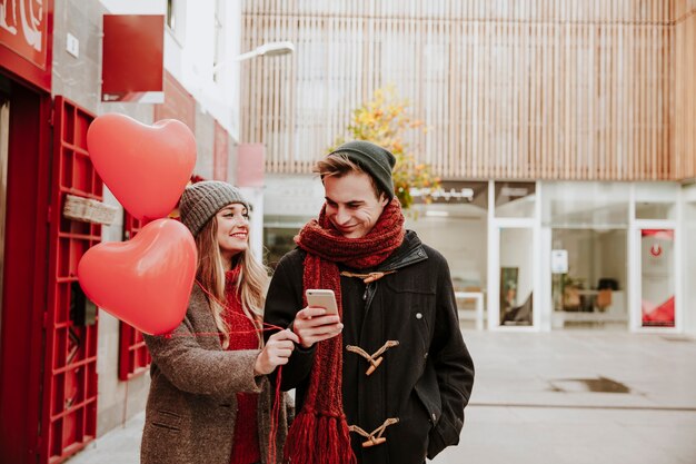 Couple with balloons and smartphone