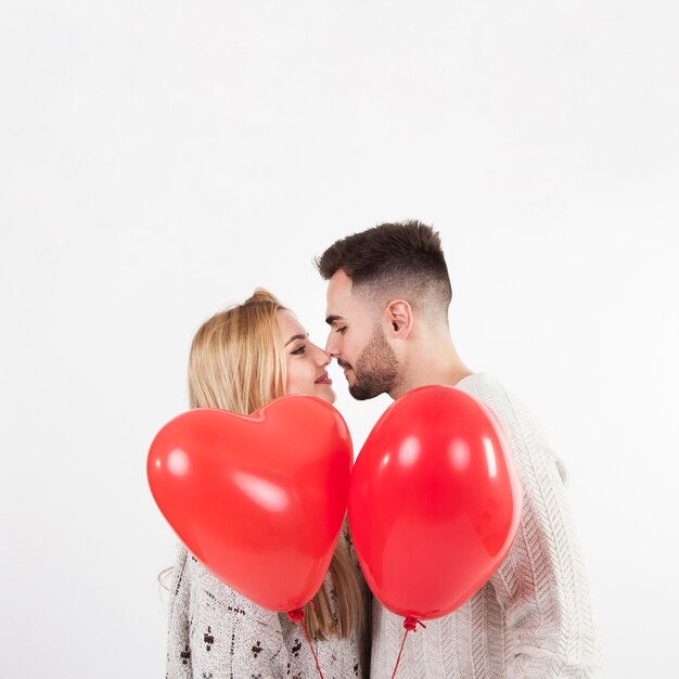 Couple with balloons touching noses