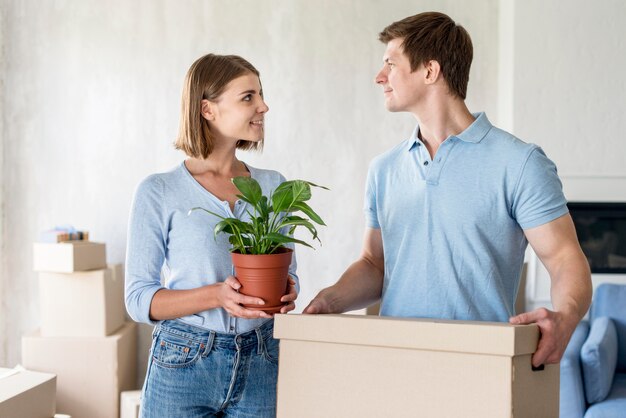 Couple with box and plant ready to move out