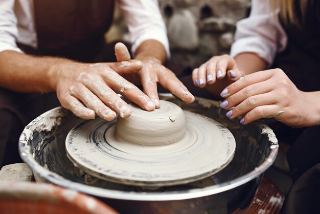 Couple with brown aprons making a vase