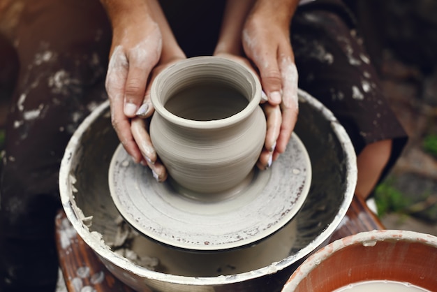 Couple with brown aprons making a vase