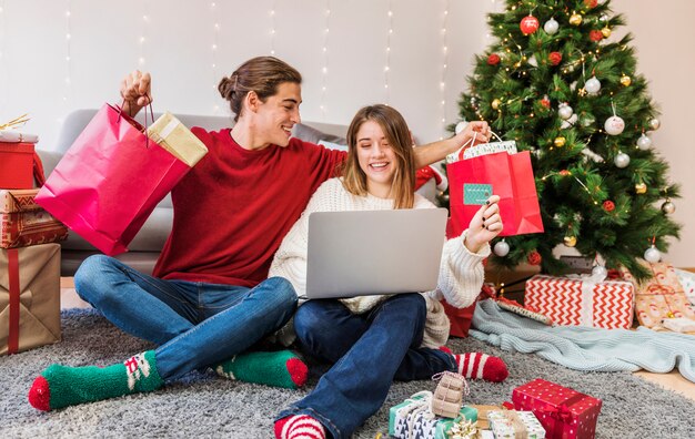 Couple with buyings and laptop 