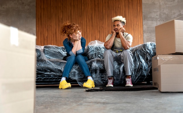 Free photo couple with cardboard boxes in their new home