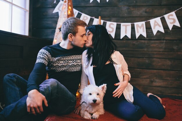 Couple with dog kissing on floor