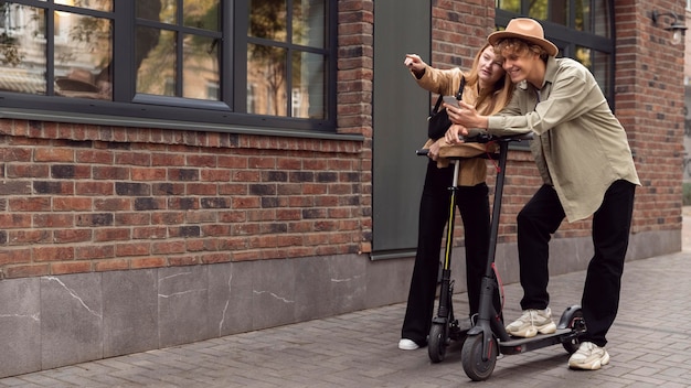 Couple with electric scooters outdoors