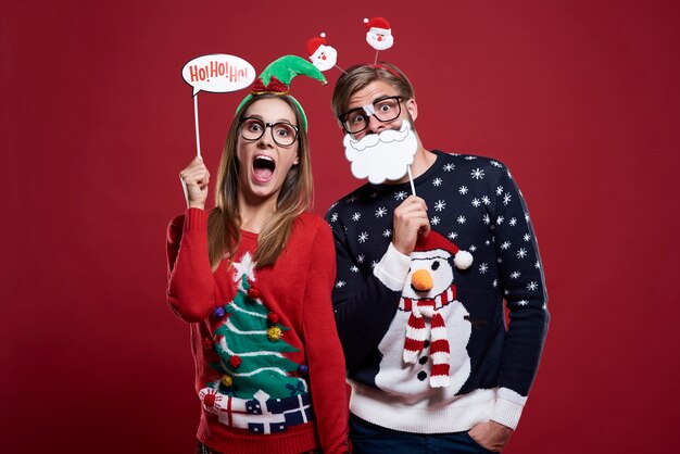 Free photo couple with funny christmas masks isolated