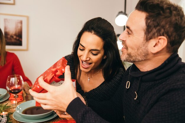 Couple with gift box at christmas dinner