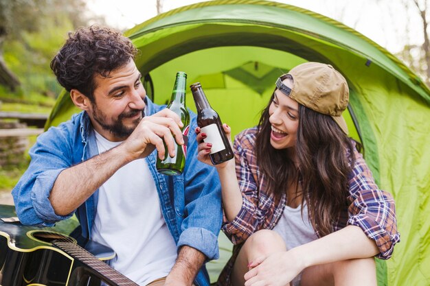 Couple with guitar clinking bottles