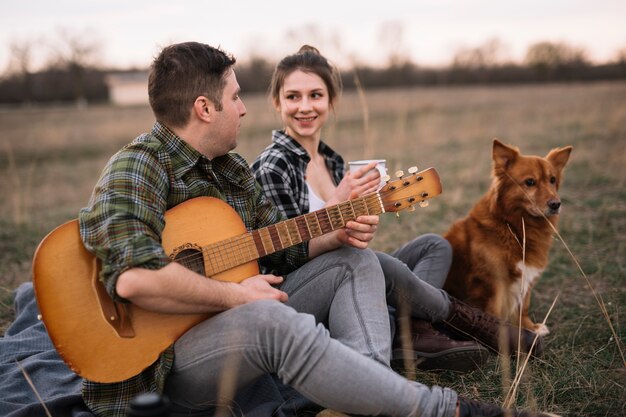 Free photo couple with guitar and cute dog