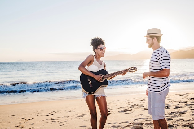 Пара с гитарой на пляже