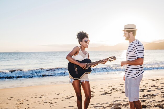 Couple with guitar at the shoreline