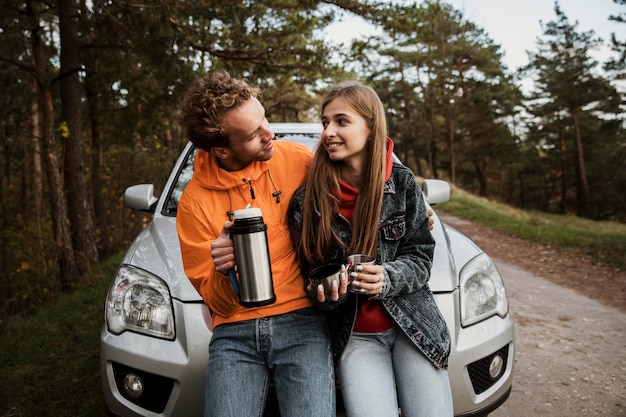Couple with hot beverage while on a road trip