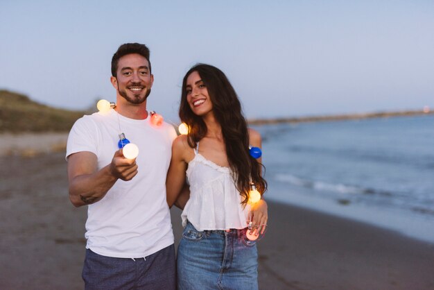 Couple with light string at the beach
