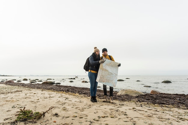 Free photo couple with map on shore