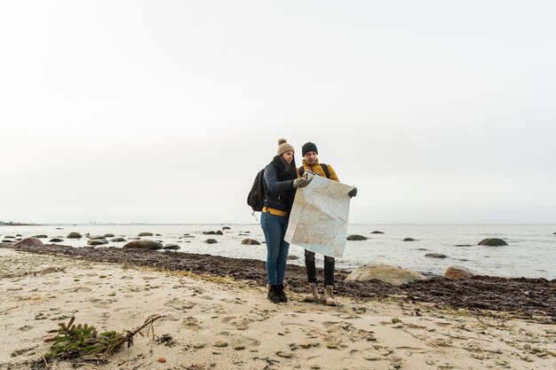 Couple with map on shore