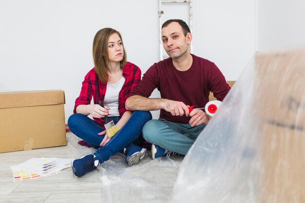 Couple with paint tools on floor