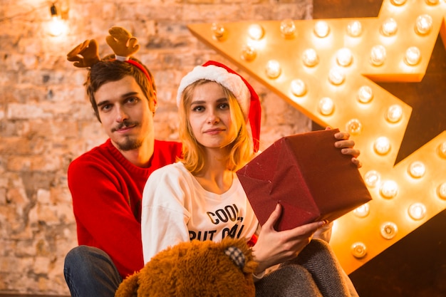 Couple with presents in front of christmas star decoration