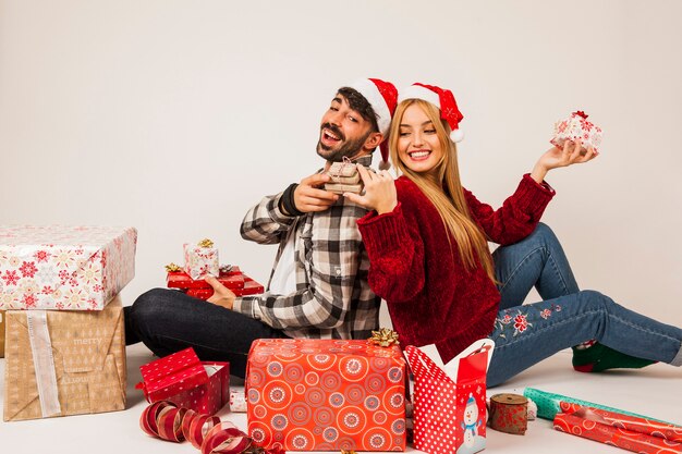 Couple with presents leaning against each other