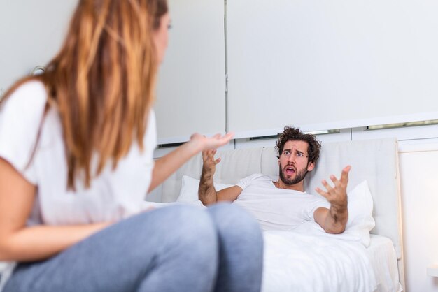 Couple with problems having disagreement in bed. frustrated couple arguing and having marriage problems  young couple into an argument on bed in bedroom