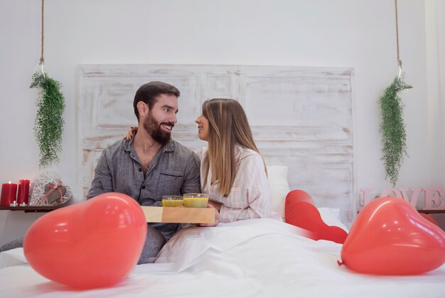 Couple with romantic breakfast on tray 