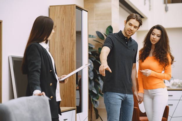 couple with salesman in furniture store