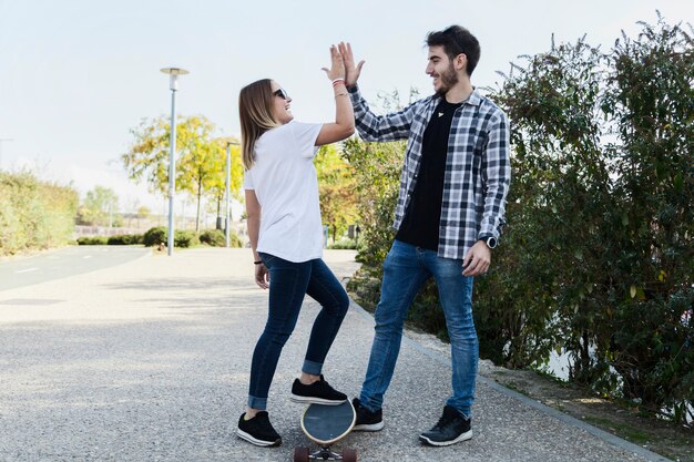 Couple with skateboard giving high five