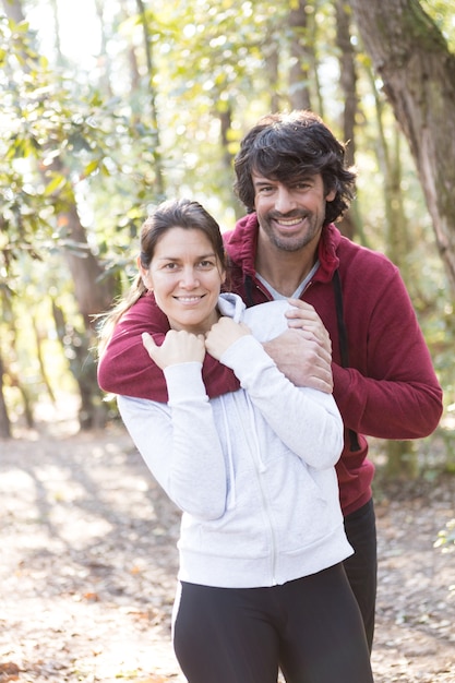Couple with sportswear hugging in the park