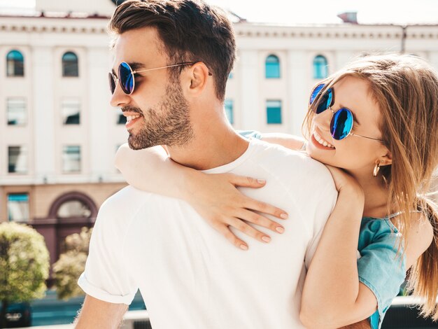 Couple with sunglasses posing in the street