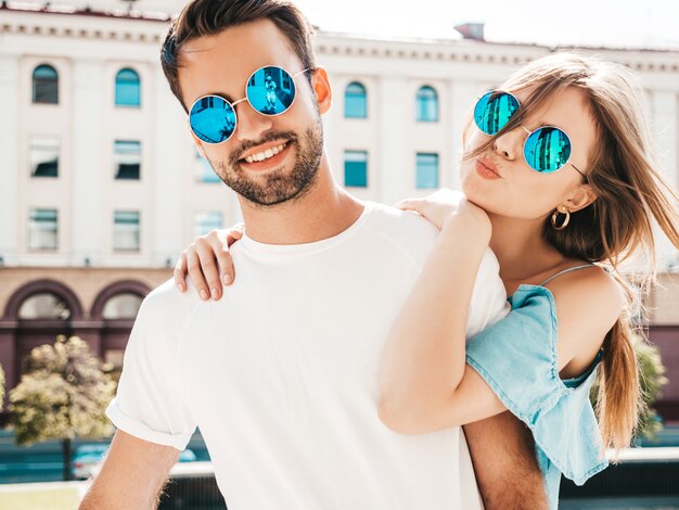 Couple with sunglasses posing in the street