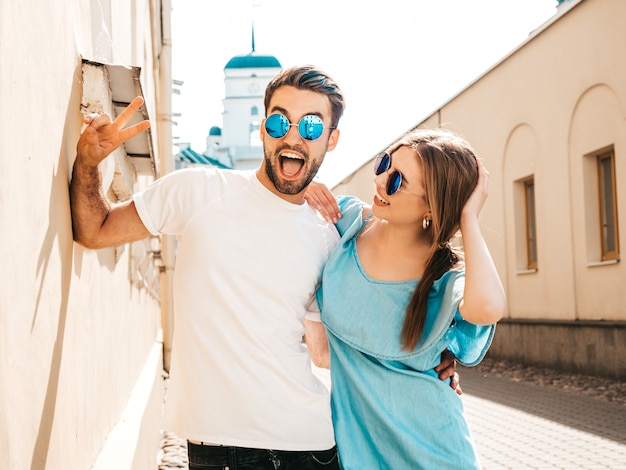 Couple with sunglasses posing in the street