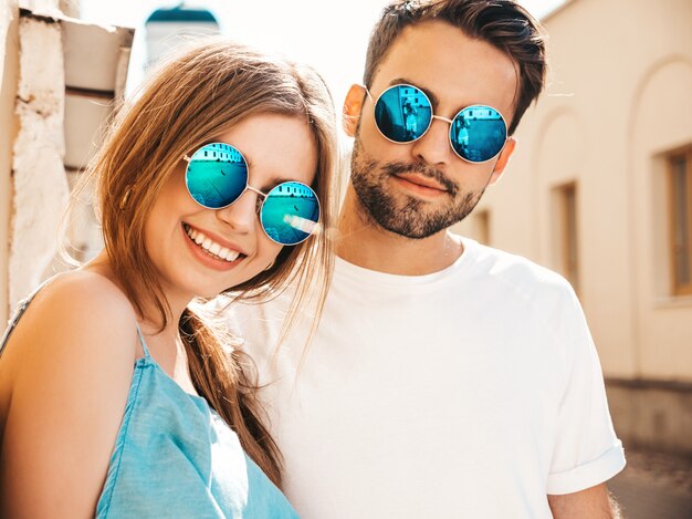 Couple with sunglasses posing in the street