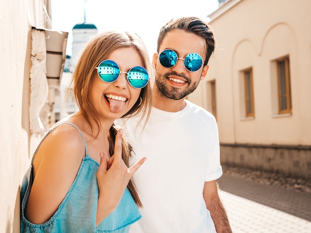 Couple with sunglasses posing in the street