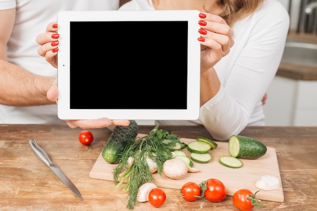 Free photo couple with tablet template in kitchen