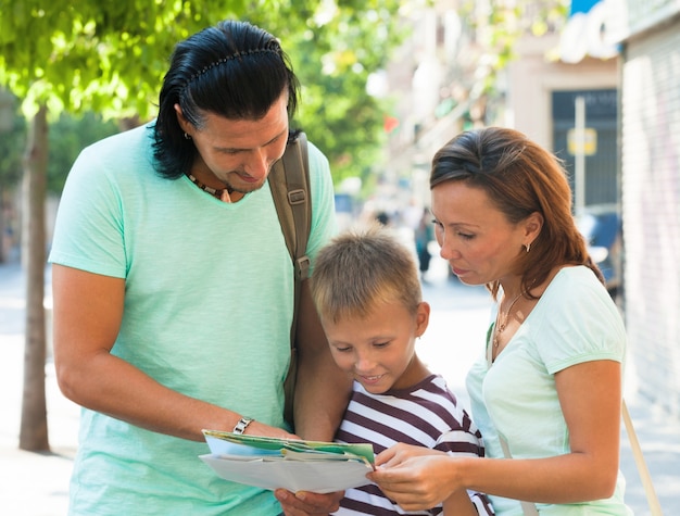 couple with teenager  looking  the map